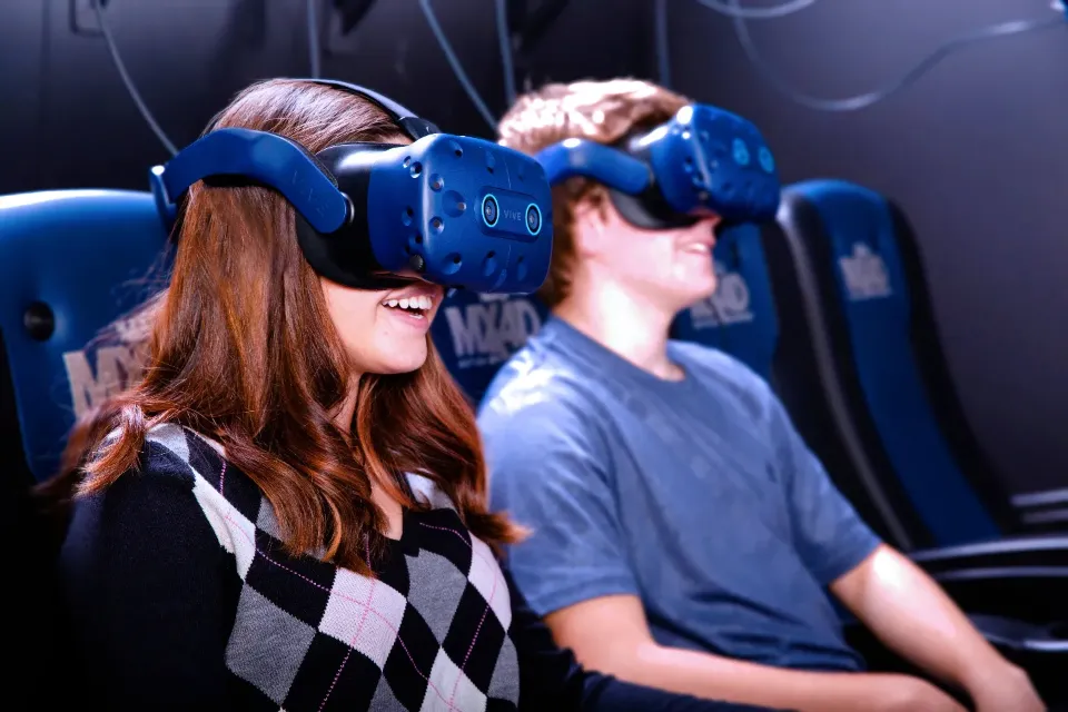 Travelers wearing VR headsets in MX4D motion seats